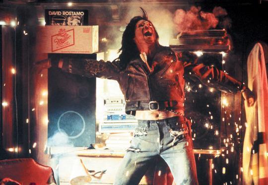 a still from the movie The Lost Boys. a vampire has been hit in the chest by a wooden arrow and is pinned to a stereo system, which is sparking and catching fire. 
Jimmy Barnes is playing...